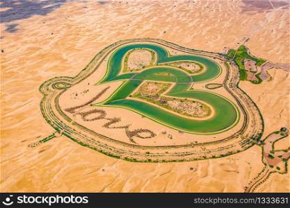 Aerial top view of love lake and sand desert, Heart shaped lakes in Al Qudra in Dubai, United Arab Emirates or UAE. A new tourist destination for valentine day. Natural landscape background