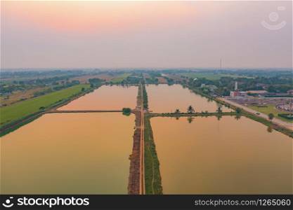 Aerial top view of lush green trees and river or lake from above in tropical forest in national park and mountain or hill in summer season in Thailand. Natural landscape background.