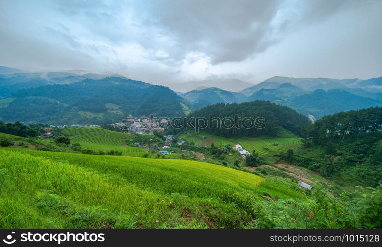 Aerial top view of paddy rice terraces, green agricultural fields in countryside or rural area of Mu Cang Chai, Yen Bai, mountain hills valley at sunset in Asia, Vietnam. Nature landscape background.