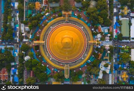 Aerial top view of Phra Pathommachedi temple at sunset. The golden buddhist pagoda with residential houses, urban city of Nakorn Pathom district, Thailand. Holy Thai architecture.