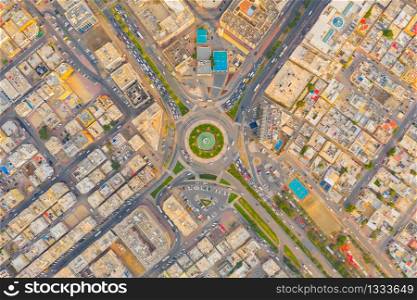 Aerial top view of roundabout, highway junctions. Roads or streets shape circle in structure of architecture and technology transportation concept. Urban city, Dubai downtown at sunset, UAE country.