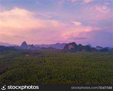 Aerial top view of Samet Nangshe, mountain valley hills, and tropical green forest trees at sunset with Andaman sea in Phang Nga Bay in summer, Thailand in travel trip. Natural landscape background.