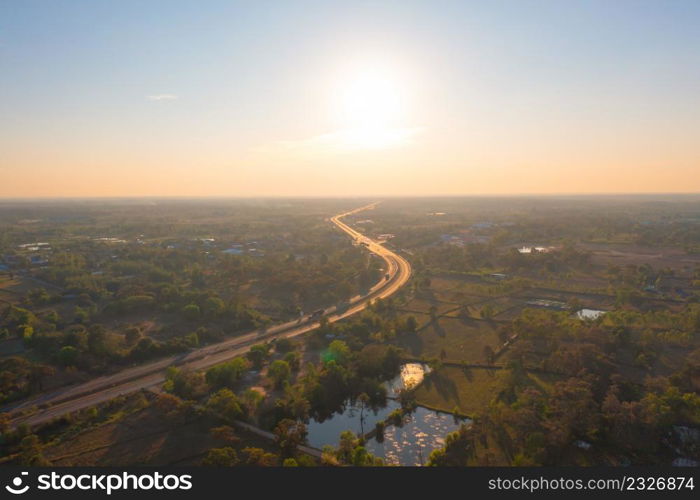 Aerial top view of street road with lush green trees from above in tropical forest at sunset. Natural landscape background.