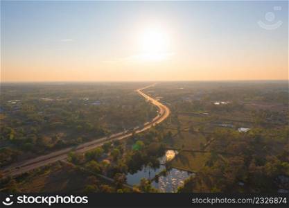 Aerial top view of street road with lush green trees from above in tropical forest at sunset. Natural landscape background.