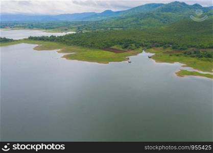 Aerial top view of trees, river or lake in tropical forest in national park and mountain or hill in summer season in Kanchanaburi district, Thailand. Natural landscape background.