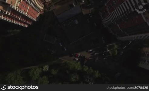 Aerial top view of typical modern sleeping district with residential buildings roofs with yard with trees and trees and playground at summer, Moscow, Russia