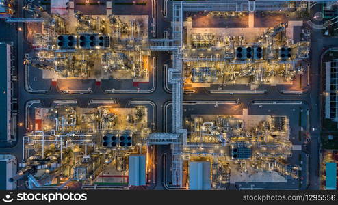 Aerial top view oil and gas tank with oil refinery background at night, Business petrochemical industrial, Refinery factory oil storage tank and pipeline, Ecosystem and healthy environment concepts.