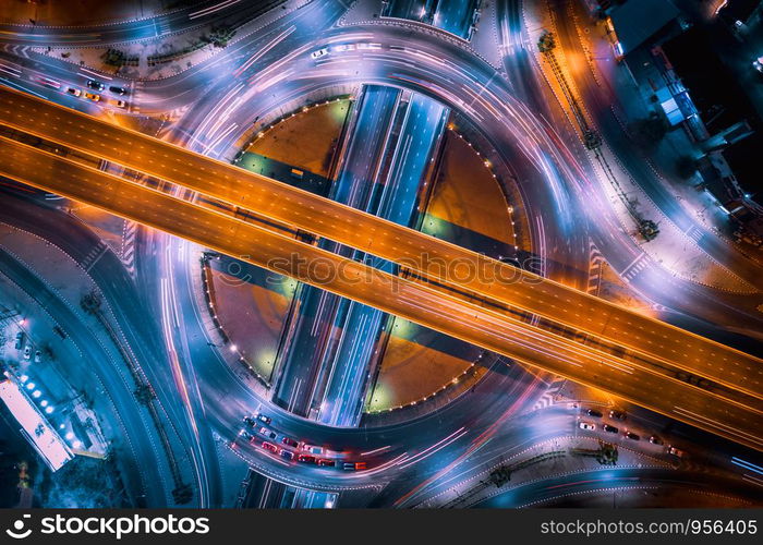 aerial top view ring road interchange and motorway expressway bypass for cars transportation connecting the city at night in Thailand from drone camera