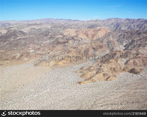 Aerial veiw of remote California desert with mountain range in background.