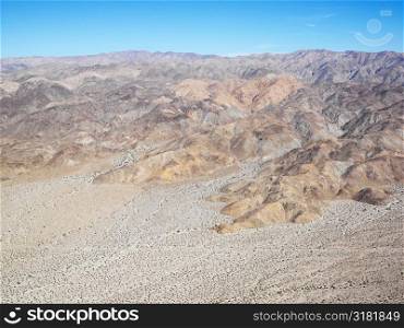 Aerial veiw of remote California desert with mountain range in background.