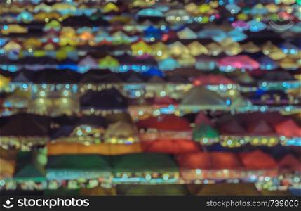 Aerial view colorful background of blurred city flea market at night. VIntage filtered tone image