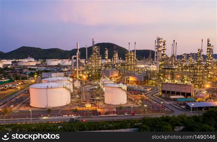Aerial view drone of oil storage tank with oil refinery factory industrial. Oil refinery plant at beautiful sky sunset and twilight. industry factory concept and transportation.