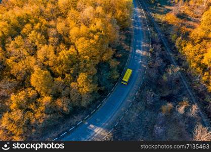 Aerial view from drone top view. Aerial view amazing over road with yellow bus, railway and colorful autumn trees along