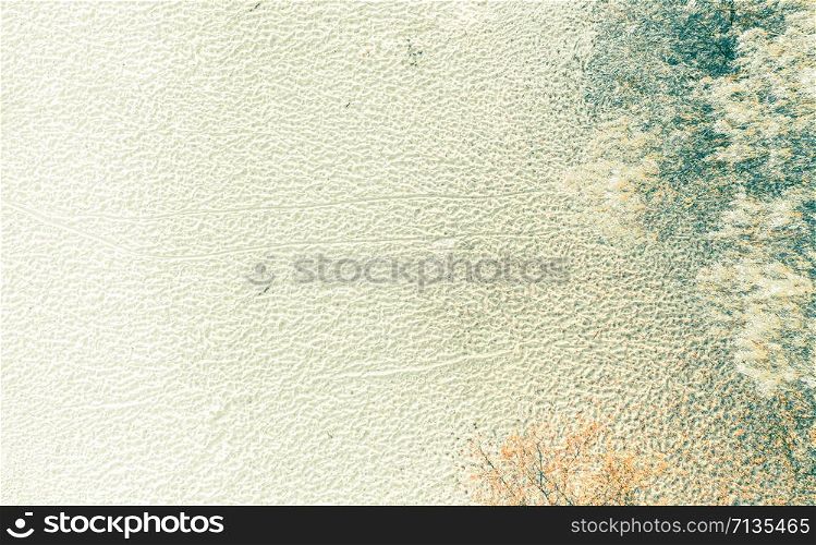 Aerial view from drone top view. Aerial view over autumn empty beach. Fanciful drawings on the sand Beautiful fall nature travel or minimalistic background. Coloring and processing photo