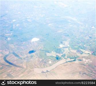 Aerial view from the airplane window on the fields and villages. Aerial view fields