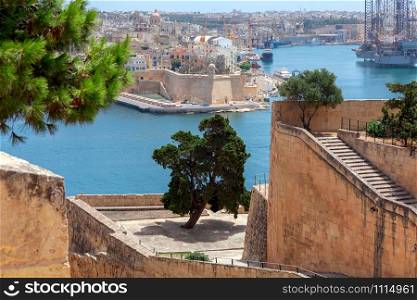 Aerial view from the fortress wall on the historical part of the old city. Malta. Valletta.. Malta. Aerial view of the old town and the bay on a sunny morning.
