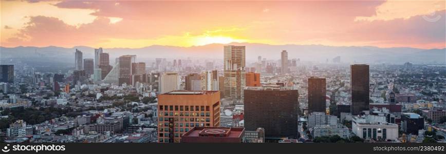 Aerial view from Torre Latinoamericana of Mexico city downtown skyscrapers and mountains at sunset