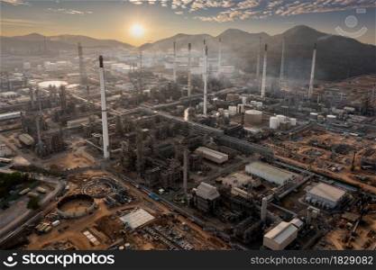 Aerial view industry factory oil and gas chemical tank and smoke with oil refinery plant zone at morning over the sunlight background