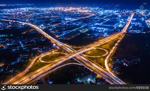 aerial view interchange ring road and motorway freeway highways and moving headlight cars transportation with over lighting the city background at night aerial view Thailand
