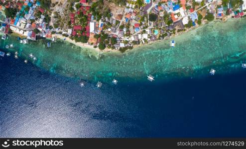 Aerial view local living of philippines at Moalboal a small town on the South-West of Cebu island, Moalboal is a deep clean blue ocean and has many local Filipino boats in the sea. Moalboal, Cebu, Philippines.