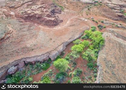 aerial view of a desert in the Moab area, Utah, with a canyon, jeep trail and SUV