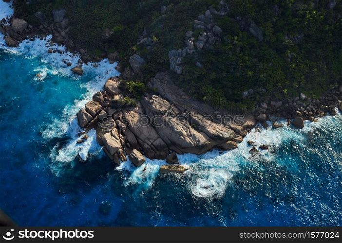 Aerial view of a rocky coastline in a tropical island with blue ocean