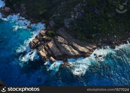 Aerial view of a rocky coastline in a tropical island with blue ocean