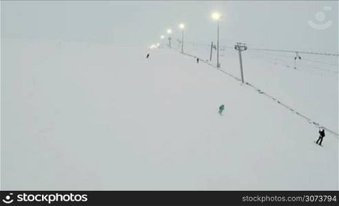 Aerial view of a skiers on slope and chair lifts on ski resort