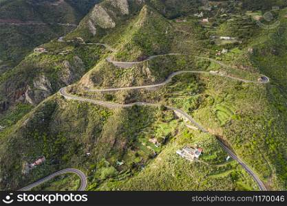 Aerial view of a winding road along a large mountain