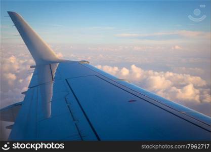 Aerial view of airplane wing above the clouds.
