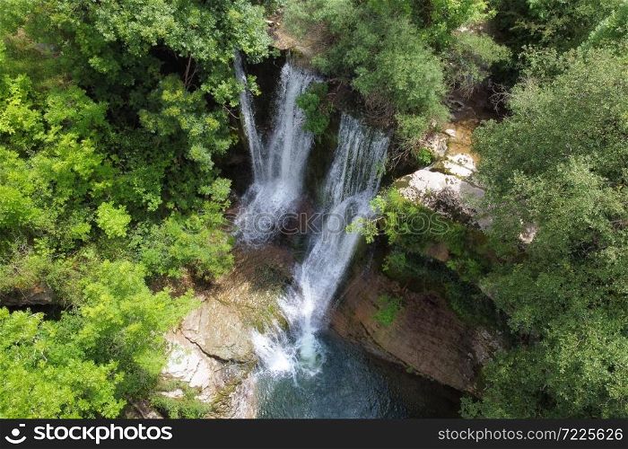 Aerial view of an Idyllic rain forest waterfall, stream flowing in the lush green forest. High quality image.. Aerial view of an Idyllic rain forest waterfall, stream flowing in the lush green forest.