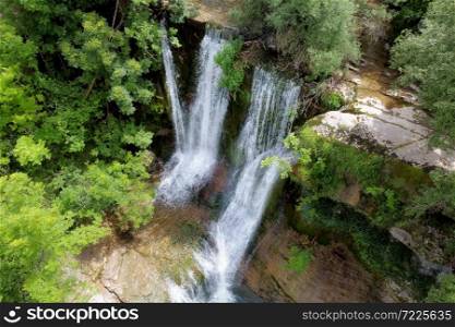 Aerial view of an Idyllic rain forest waterfall, stream flowing in the lush green forest. High quality image.. Aerial view of an Idyllic rain forest waterfall, stream flowing in the lush green forest.