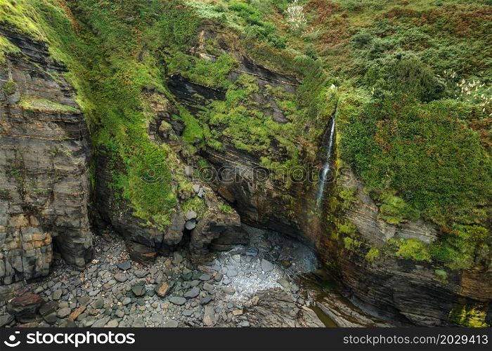 Aerial view of an idyllic waterfall at tropical coastline scenery. High quality photo. . Aerial view of an idyllic waterfall at tropical coastline scenery.