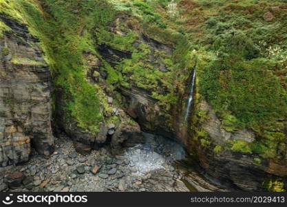 Aerial view of an idyllic waterfall at tropical coastline scenery. High quality photo. . Aerial view of an idyllic waterfall at tropical coastline scenery.