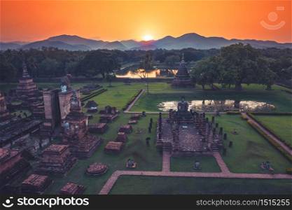 Aerial view of Ancient Buddha statue at sunset in Wat Mahathat temple, Sukhothai Historical Park, Thailand.