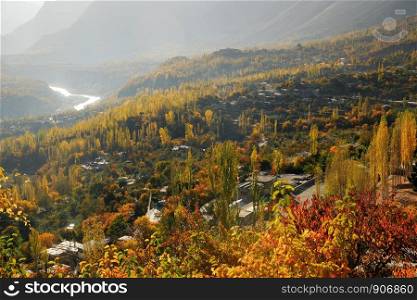 Aerial view of autumn colorful Hunza valley in the morning with Karakoram mountain range in the background. Gilgit-Baltistan, Pakistan.