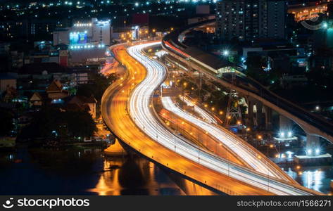 Aerial view of Bangkok Downtown skyline, highway roads or street and Chao Phraya River in Thailand. Financial district in smart urban city. Skyscraper and high-rise buildings at night.