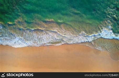 Aerial view of beach with waves rolling into the shore with copy space for travel, holidays vacation outdoor background, Andaman sea, Phuket bay island in summer season, Thailand. Top view