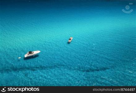 Aerial view of beautiful luxury yacht and boat in blue sea at sunset in summer. Sardinia island, Italy. Top view of speed boat, sea coast, azure clear water. Travel. Tropical landscape. Yachting 