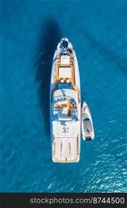 Aerial view of beautiful luxury yacht and boat in blue sea at sunset in summer. Sardinia island, Italy. Top view of speed boat, sea coast, transparent water. Travel. Tropical landscape. Yachting 