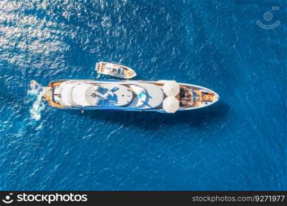 Aerial view of beautiful luxury yacht and boat in blue sea at sunset in summer. Sardinia island, Italy. Top view of speed boat, sea coast, transparent water. Travel. Tropical landscape. Yachting