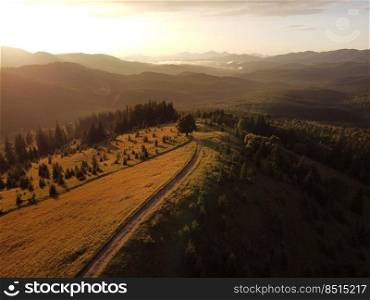 Aerial view of beautiful mountain Carpathians, Ukrai≠in sunlight. Dro≠filmed an landscape with coniferous and beech forests, around a winding serpenti≠road, copter aerial photo.. Aerial view of beautiful mountain Carpathians, Ukrai≠in sunlight. Dro≠filmed an landscape with coniferous and beech forests, around a winding serpenti≠road, copter aerial photo