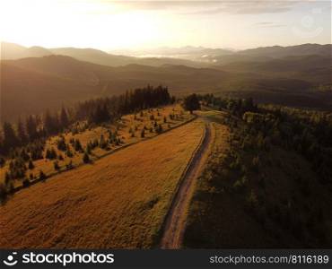 Aerial view of beautiful mountain Carpathians, Ukraine in sunlight. Drone filmed an landscape with coniferous and beech forests, around a winding serpentine road, copter aerial photo.. Aerial view of beautiful mountain Carpathians, Ukraine in sunlight. Drone filmed an landscape with coniferous and beech forests, around a winding serpentine road, copter aerial photo