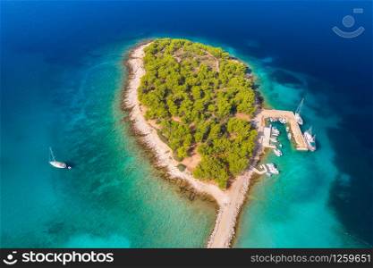 Aerial view of beutiful small island in sea bay at sunny bright day in summer in Murter, Croatia. Top view of transparent blue water, green trees, sandy beach, boats and yachts. Tropical landscape
