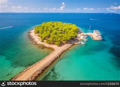 Aerial view of beutiful small island in sea bay at sunny bright day in summer in Murter, Croatia. Top view of transparent blue water, green trees, sandy beach, boats and yachts. Tropical landscape