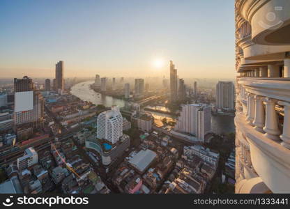 Aerial view of boats and Taksin Bridge with Chao Phraya River, Bangkok Downtown. Thailand. Financial district and business centers in smart urban city. Skyscraper and high-rise buildings at sunset.