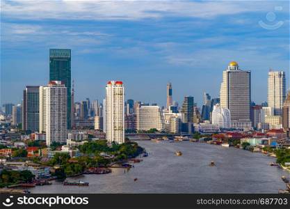 Aerial view of boats and Taksin Bridge with Chao Phraya River, Bangkok Downtown. Thailand. Financial district and business centers in smart urban city. Skyscraper and high-rise buildings at sunset.
