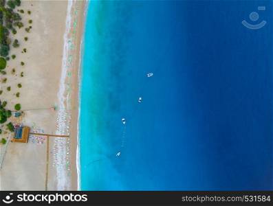 Aerial view of boats in mediterranean sea in Oludeniz,Turkey. Beautiful summer seascape with boats, clear azure water and sandy beach in sunny day. Top view of yachts from drone. Nature background. Aerial view of boats in mediterranean sea in Oludeniz,Turkey