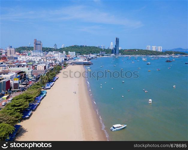 Aerial view of boats in Pattaya sea, beach in summer, and urban city with blue sky for travel background. Chon buri Province, Thailand.