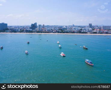 Aerial view of boats in Pattaya sea, beach in summer, and urban city with blue sky for travel background. Chon buri Province, Thailand.